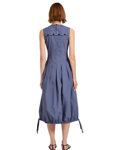Woman wearing a blue dress with black buttons on a white background