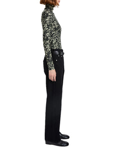 Person wearing a patterned long-sleeve top and black pants on a white background